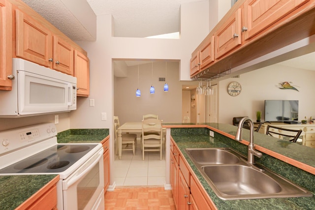 kitchen with white appliances, sink, a textured ceiling, and light tile patterned floors