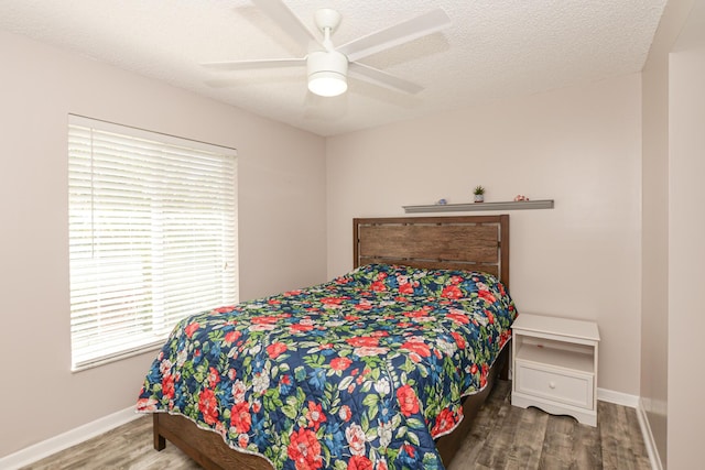 bedroom with ceiling fan, wood-type flooring, and a textured ceiling