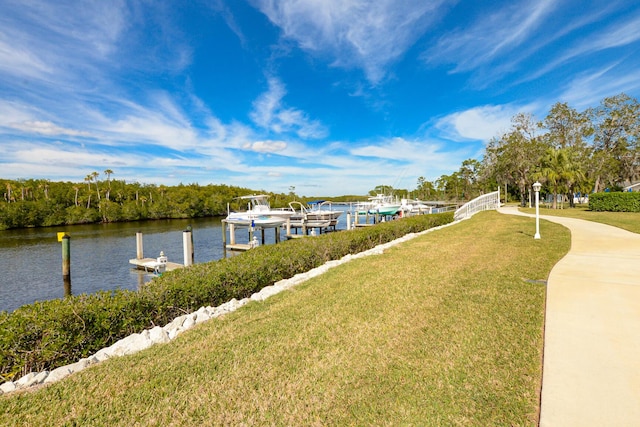 dock area featuring a water view and a lawn