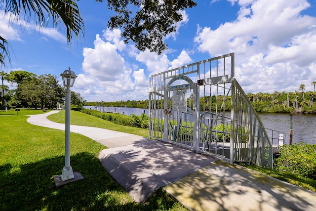 surrounding community featuring a water view and a lawn