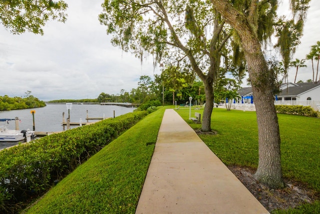 view of community with a water view, a yard, and a boat dock