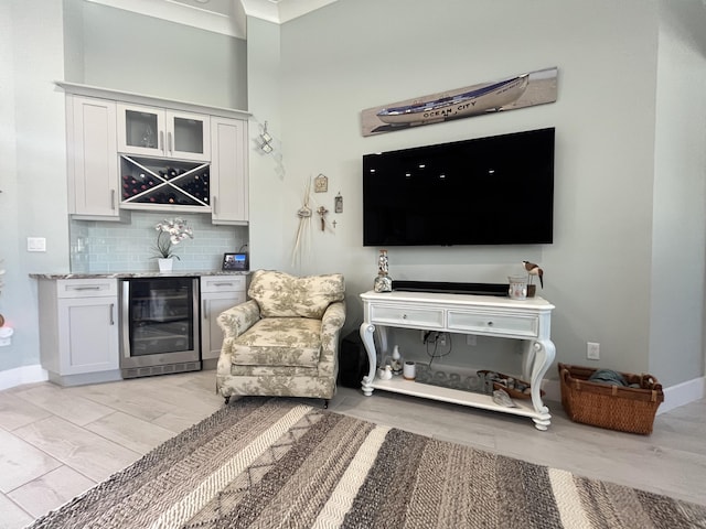 sitting room featuring bar, beverage cooler, and light hardwood / wood-style floors