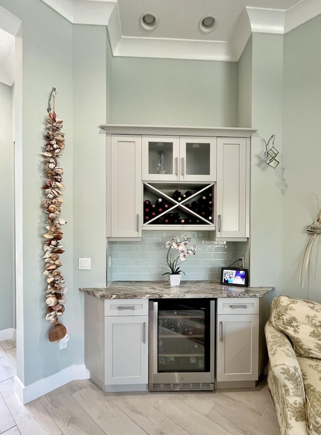 bar with tasteful backsplash, white cabinetry, and wine cooler