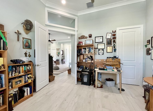 office space with ceiling fan, ornamental molding, and light hardwood / wood-style floors