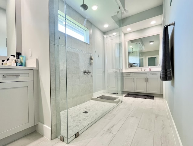 bathroom featuring a tile shower and vanity