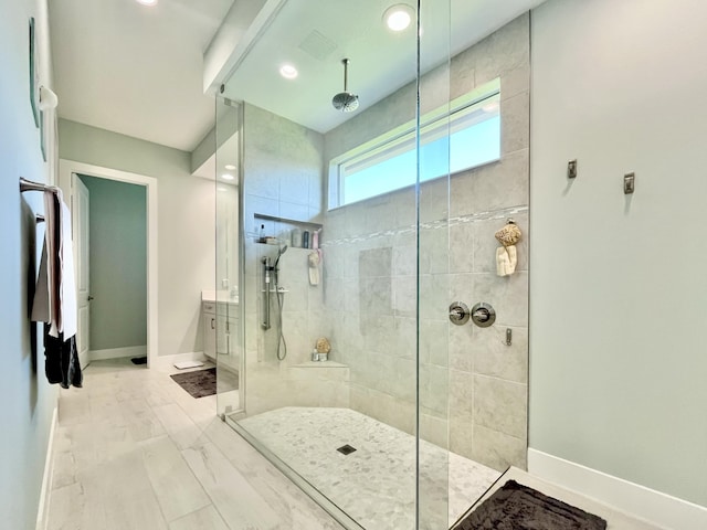 bathroom with vanity, wood-type flooring, and tiled shower