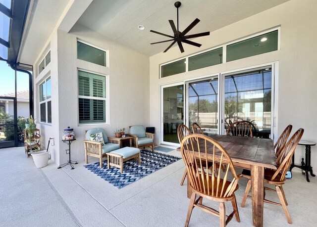 view of patio with ceiling fan and glass enclosure