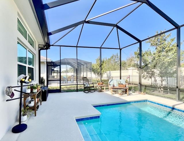 view of pool with a patio and glass enclosure