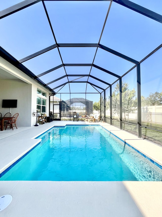 view of swimming pool with a patio and a lanai