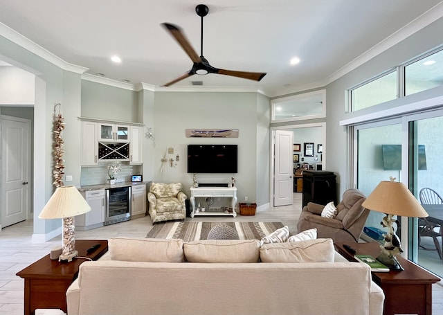 living room featuring wine cooler, ceiling fan, bar, and crown molding