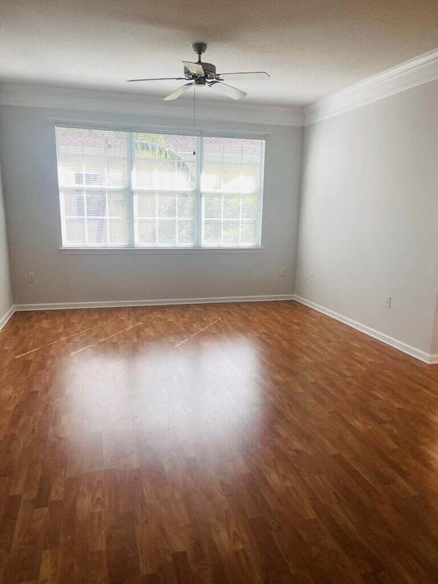 empty room with crown molding, ceiling fan, and dark hardwood / wood-style flooring