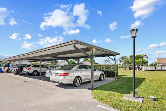 view of vehicle parking featuring a carport and a lawn