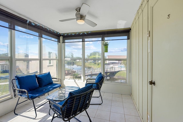 sunroom / solarium with a water view and ceiling fan