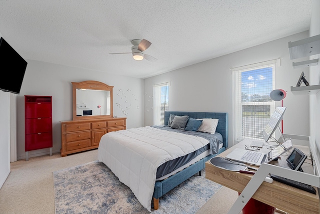 carpeted bedroom with a textured ceiling and ceiling fan