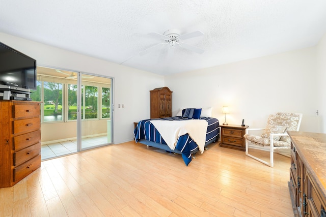 1153 Cambridge Unit G, Deerfield Beach, FL 33442 - bedroom with a textured ceiling, light wood finished floors, access to exterior, and ceiling fan