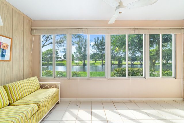 unfurnished sunroom with a water view and ceiling fan