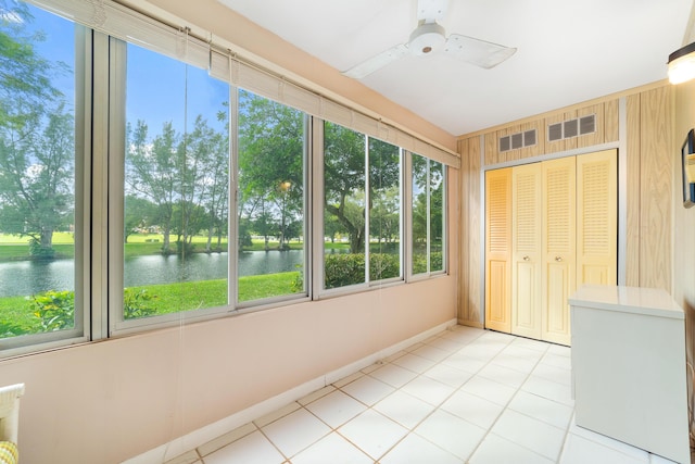 unfurnished sunroom with ceiling fan and a water view