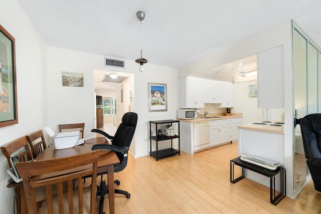 office space with sink, light hardwood / wood-style floors, and a textured ceiling