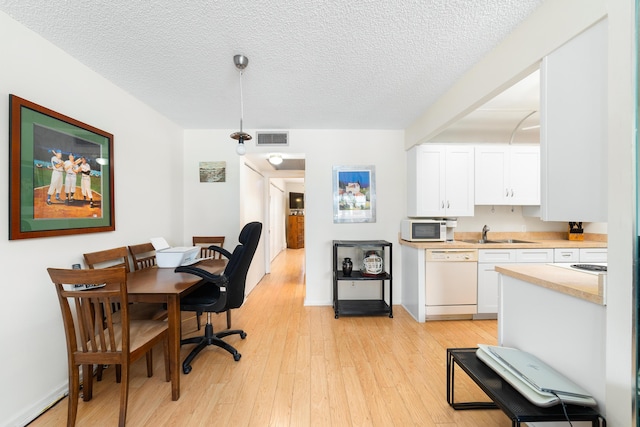 1153 Cambridge Unit G, Deerfield Beach, FL 33442 - dining area with light wood finished floors, a textured ceiling, and baseboards