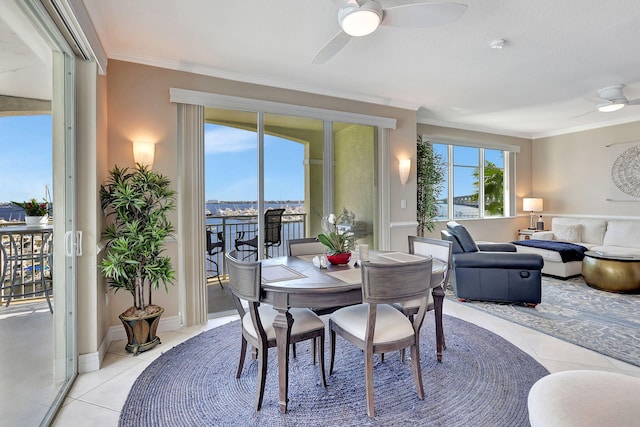 tiled dining space featuring ornamental molding, a water view, and ceiling fan