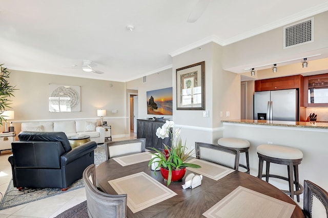 dining room with crown molding, ceiling fan, and light tile patterned floors