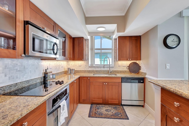 kitchen with light stone countertops, appliances with stainless steel finishes, sink, and decorative backsplash