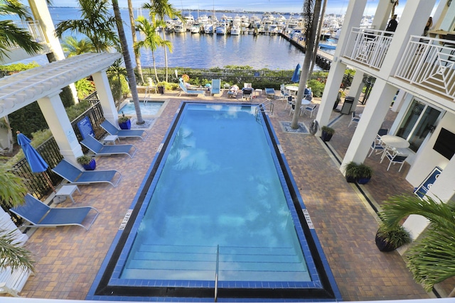 view of swimming pool with a water view and a patio area