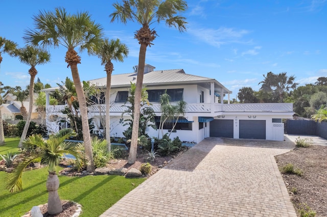 view of front of property with a balcony, a garage, and a front yard