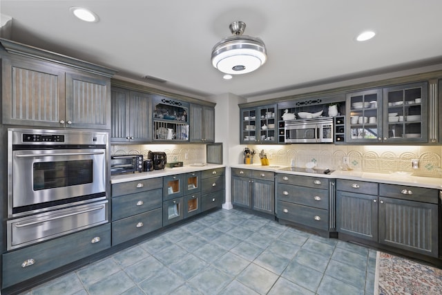 kitchen with tasteful backsplash, stainless steel appliances, and light tile patterned flooring