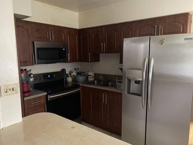 kitchen with dark brown cabinetry, sink, and stainless steel appliances