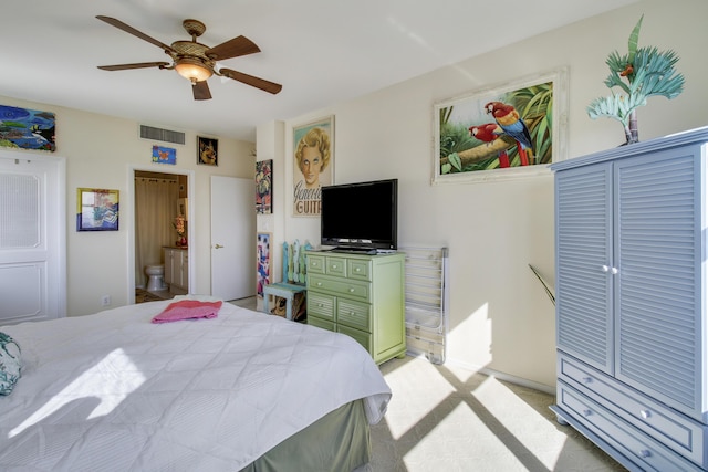 carpeted bedroom with ensuite bathroom and ceiling fan