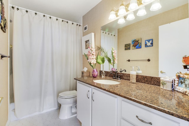 bathroom with tile patterned flooring, vanity, and toilet