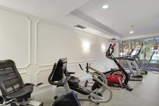 exercise room with crown molding and a tray ceiling