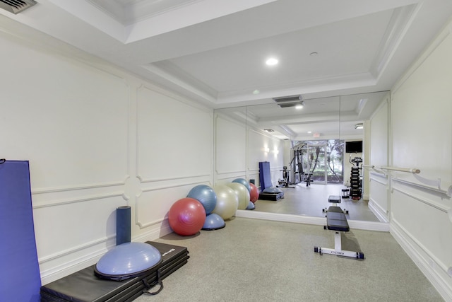 workout room with ornamental molding and a tray ceiling