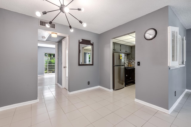 interior space featuring a textured ceiling and light tile patterned floors