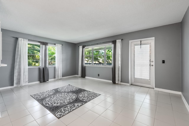 unfurnished room with light tile patterned floors and a textured ceiling