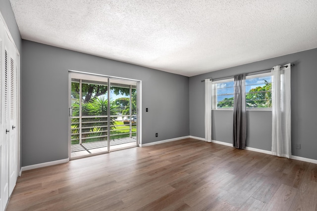 unfurnished room featuring hardwood / wood-style floors and a textured ceiling