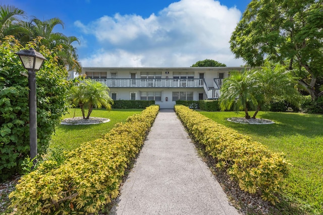 view of front of home featuring a front yard and a balcony