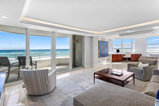 living room with a raised ceiling, expansive windows, and a wealth of natural light