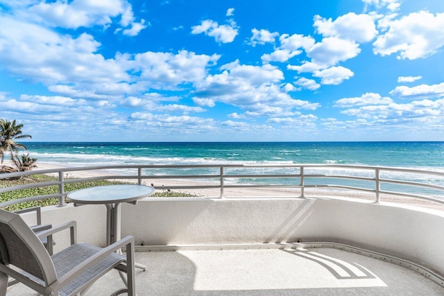 balcony with a water view and a beach view