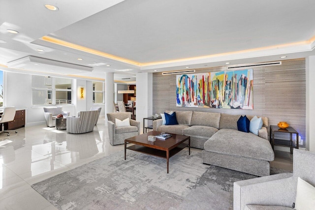 living room featuring a tray ceiling and light tile patterned floors