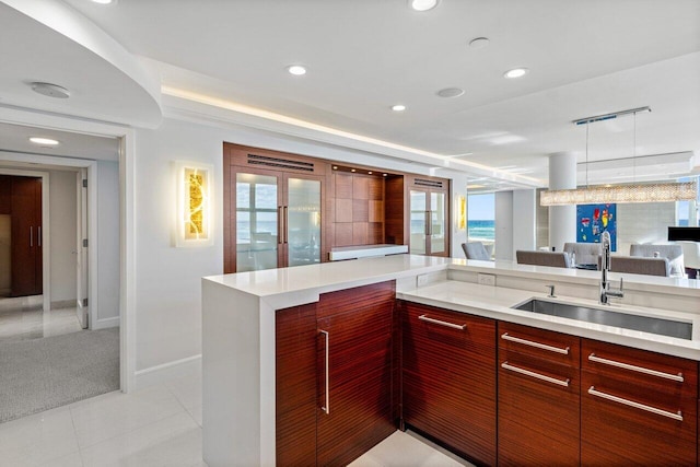 kitchen with light tile patterned flooring, kitchen peninsula, sink, and french doors