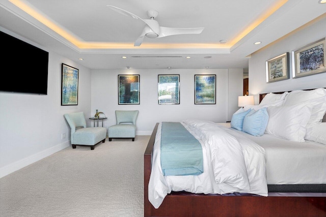 bedroom with ceiling fan, carpet flooring, and a raised ceiling