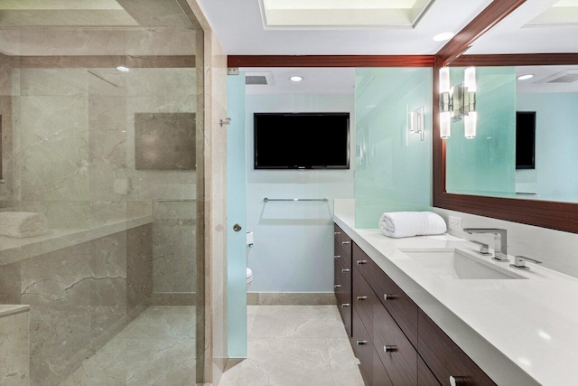 bathroom featuring vanity, tiled shower, and toilet