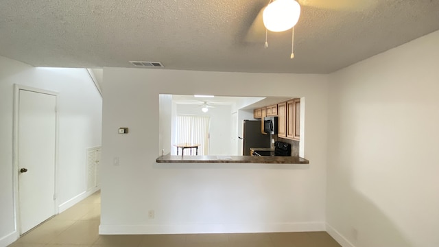 kitchen featuring visible vents, ceiling fan, freestanding refrigerator, black electric range oven, and a textured ceiling