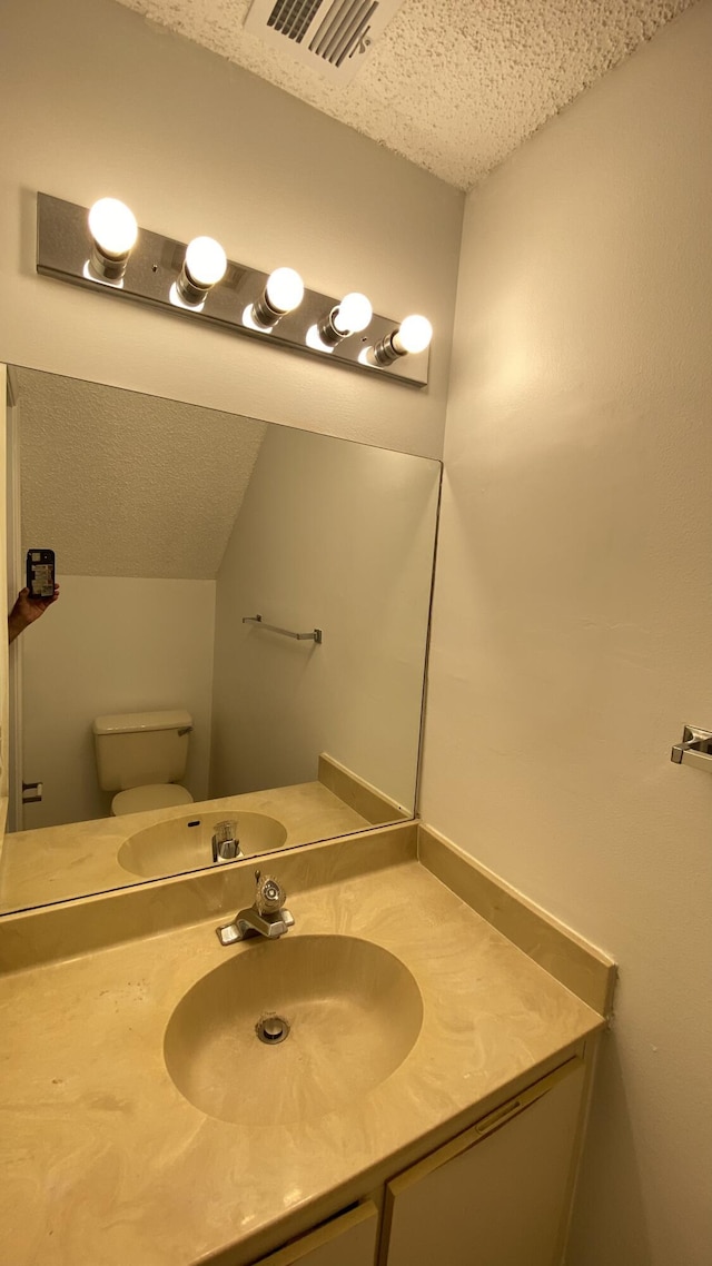 bathroom featuring visible vents, toilet, and vanity