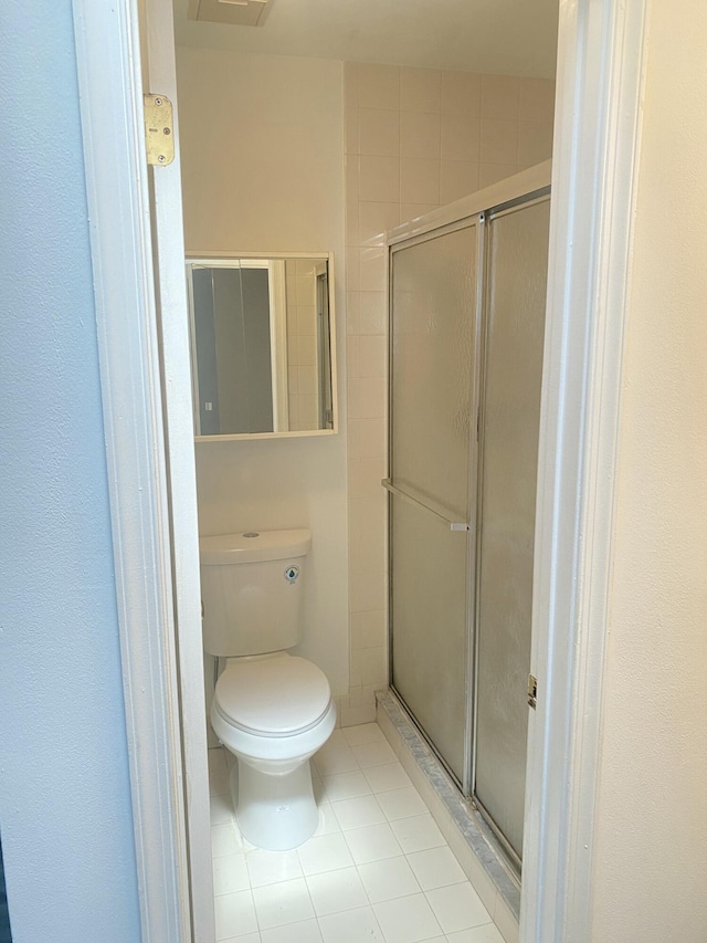 bathroom featuring tile patterned floors, toilet, visible vents, and a stall shower