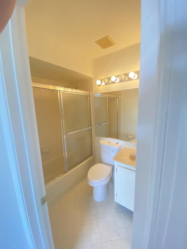 bathroom featuring vanity, visible vents, enclosed tub / shower combo, tile patterned floors, and toilet