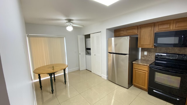 kitchen with brown cabinets, black appliances, backsplash, light tile patterned flooring, and baseboards