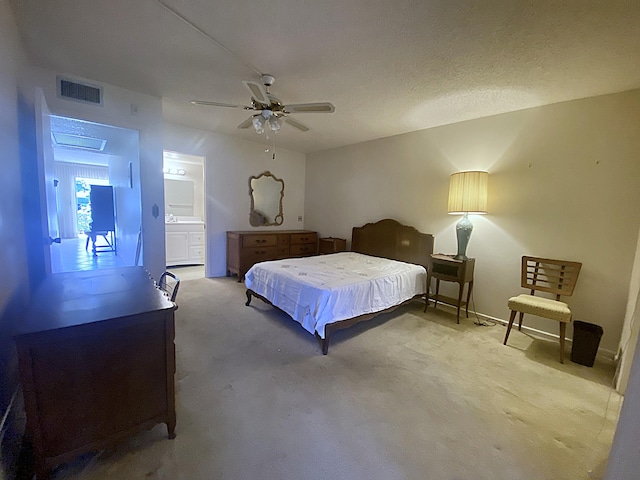 carpeted bedroom with ceiling fan, a textured ceiling, and ensuite bath